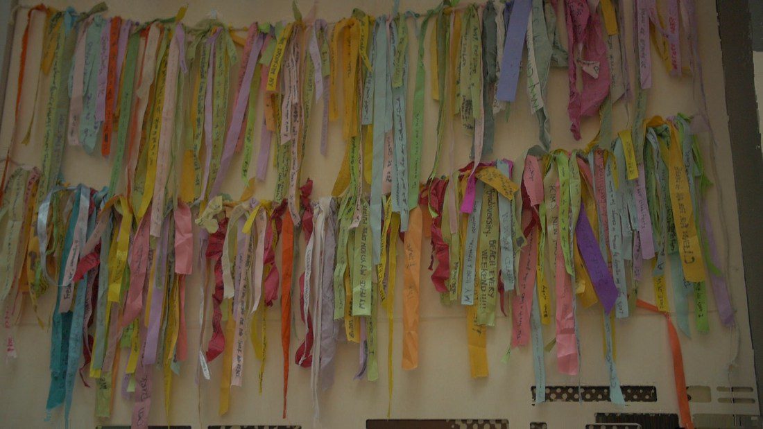 Ribbons hanging from a wall with messages written on them