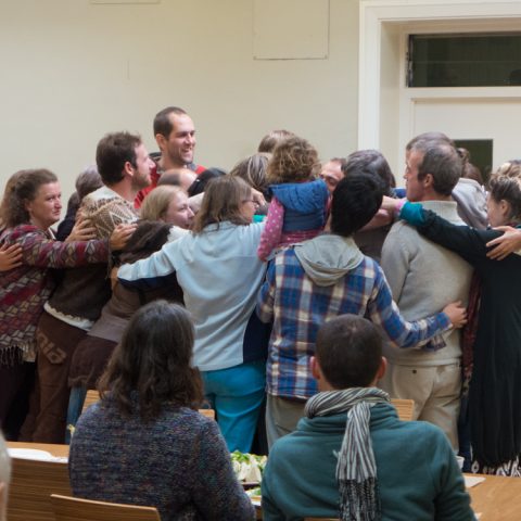 Group of people hugging in circle.
